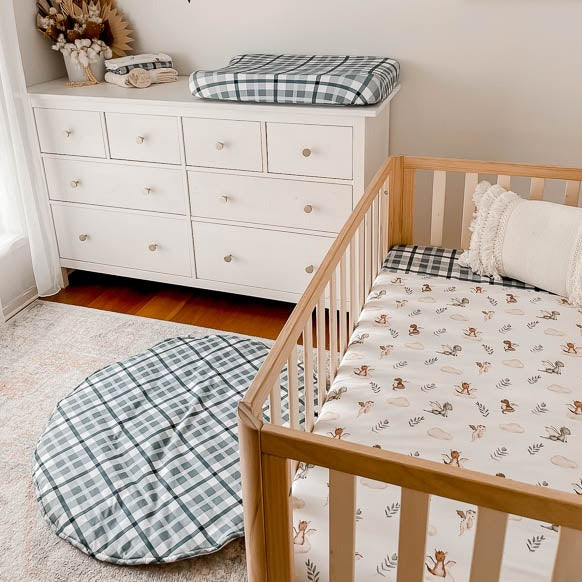 Modern nursery set up with a change mat cover, fitted cot sheet and a cotton playmat all in the blue cyprus plaid print 
