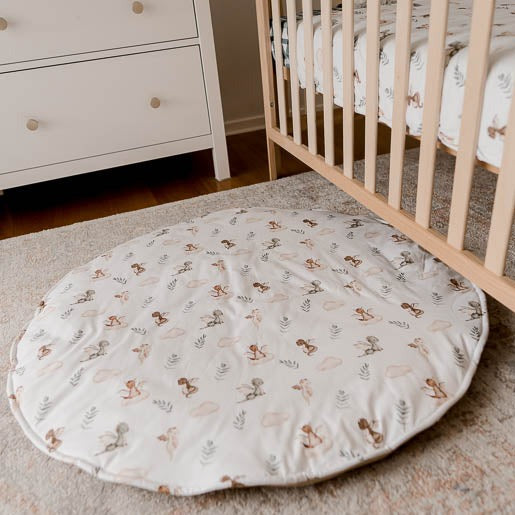 Cotton Playmat with a green, Brown and white pattern set out on a floor rug in a nursery 