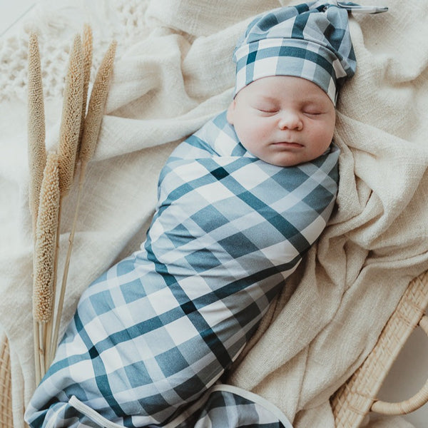 Adorable baby all wrapped up in a blue plaid swaddle wrap