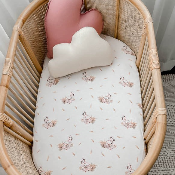 Rattan Bassinet set with adorable heart shaped pillows and a swan pattern cotton sheet