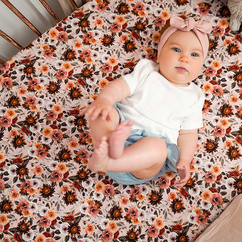 Baby girl laying in her cot on a Snuggly Jacks Oeko-tex certified 100% cotton fitted cot sheet