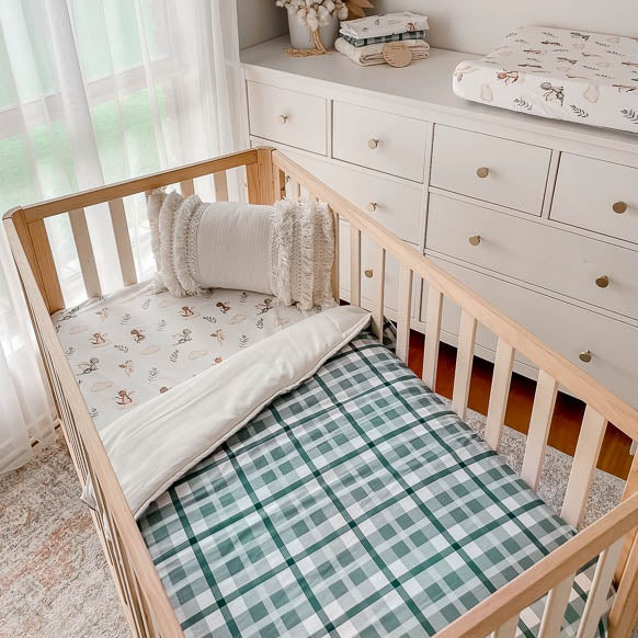 Nursery set with a collection of dragon prints matched with a blue cyprus plaid cot quilt