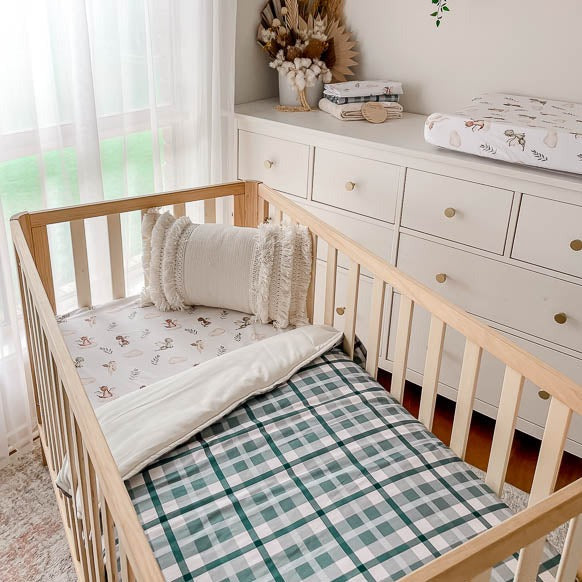 Pine Cot set with a dragon print sheet and a plaid cotton cot quilt.