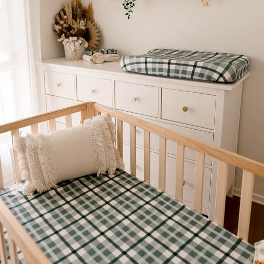 Modern nursery with snuggly jacks burp clothes, change mat cover and fitted cot sheet all in a blue plaid pattern.