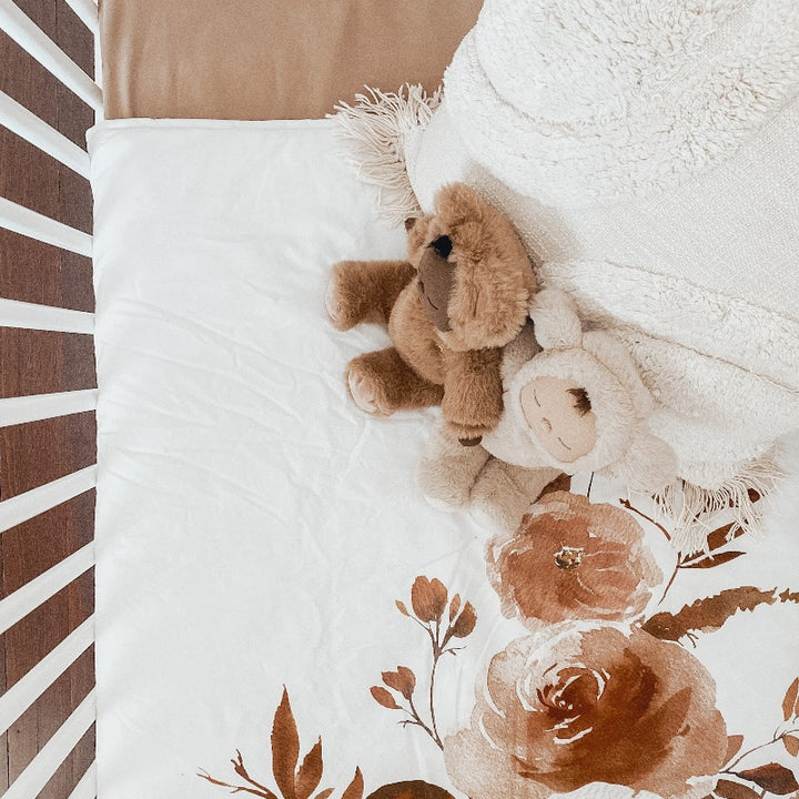 Over head shot of two plush toys living large in a cot set using snuggly jacks cotton nursery products