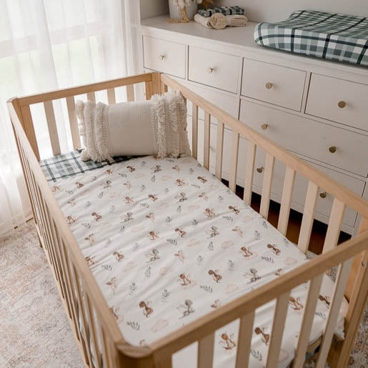 Pine cot in a modern nursery made up using a cotton filled cot quilt with dragon prints.