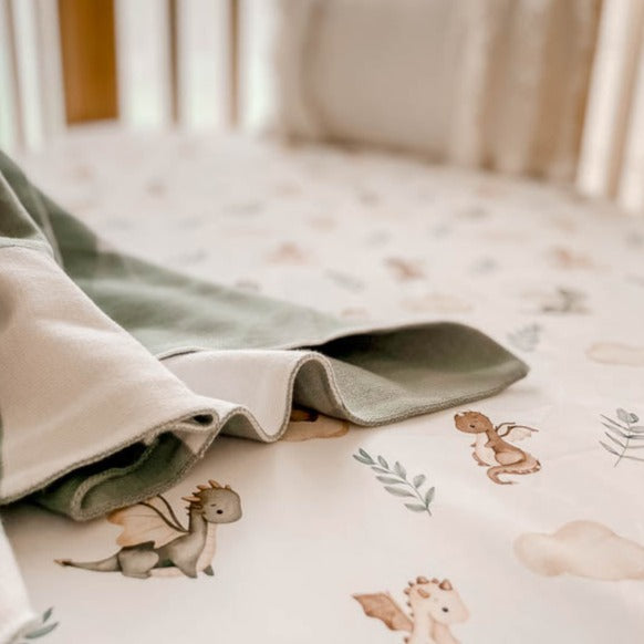 Pine cot, sheet with dragons and leaves, a green plaid cotton blanket