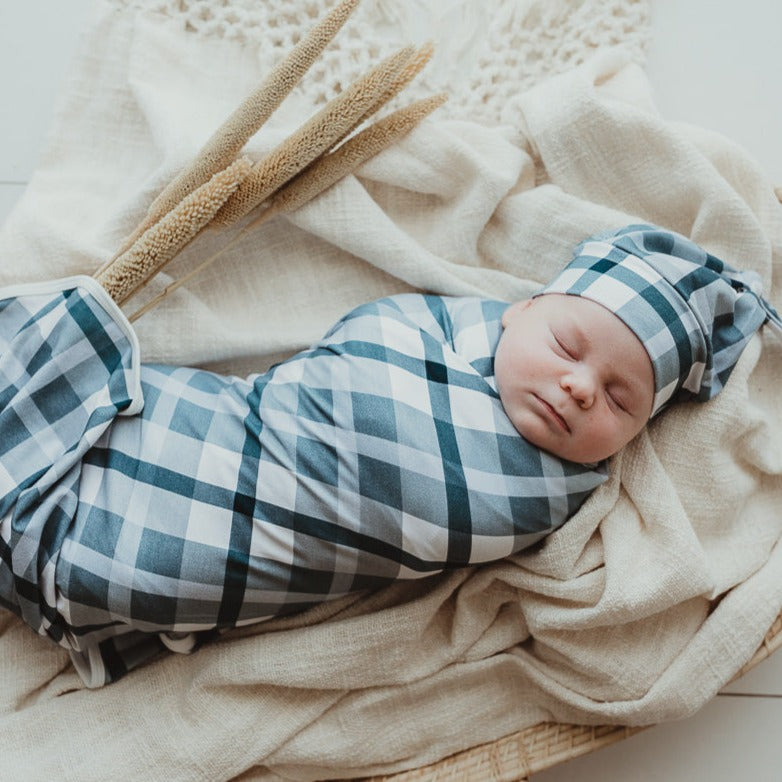 A blue jersey swaddle stretch wrap keeping a sweet little dude all snug and well rested. 