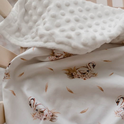 Close up of a swan print minky pram blanket