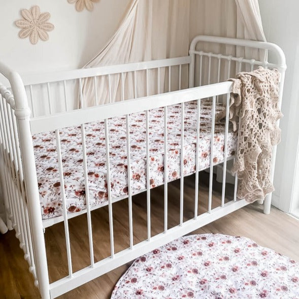 White cot placed against the nursery wall demonstarting the Willow Play Mat and Willow fitted cot sheet.