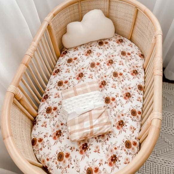 Cotton Bassinet sheet with a warm brown and soft pink floral pattern in a bassinet. 
