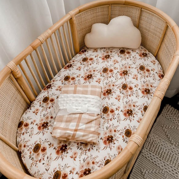 Rattan bassinet set with a snuggly jacks fitted sheet, minky throw blanket and cloud shaped pillow.