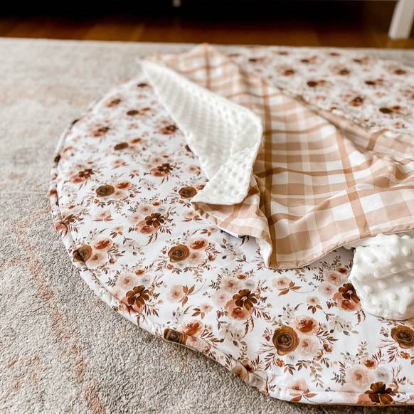 Cotton Playmat with a Brown and moroon floral pattern  set out on a floor rug