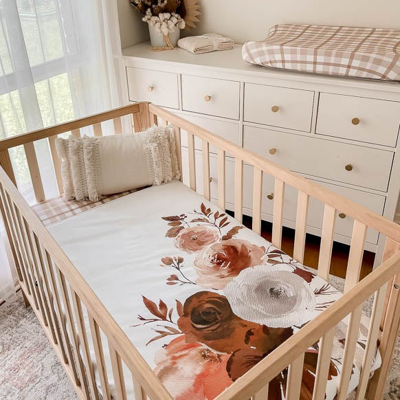 Styled nursery with plaid sheets and change mat cover showcasing the willow large print cot quilt.