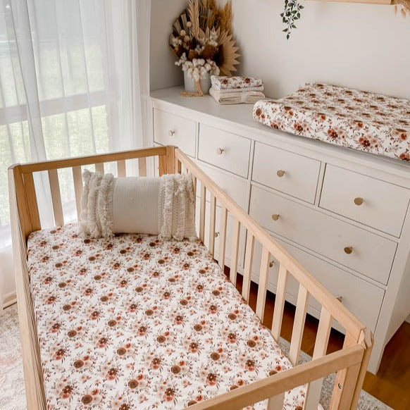 A nursery with fitted cot sheet, burp cloths and a change mat cover all in the new willow floral print from snuggly jacks Australia.
