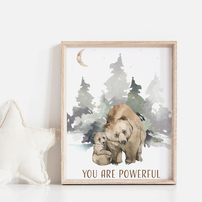 Picture of a brown bear and her cub walking in the forest, in a brown frame hanging on a nursery room wall