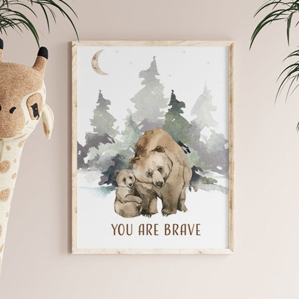 Picture hanging on a wall of a brown bear and her cub walking in the forest